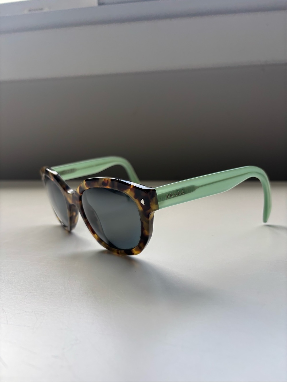 Women’s PRADA spr12s sunglasses with a tortoiseshell frame and pastel green